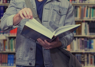 Ein Student liest ein Buch in der Bücherei